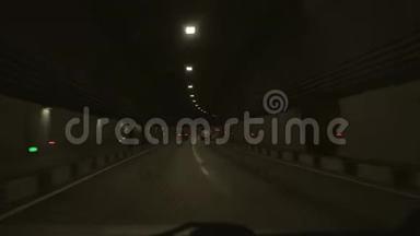 从穿过隧道的汽车上看到。 这辆汽车穿过山里的一条长长的隧道